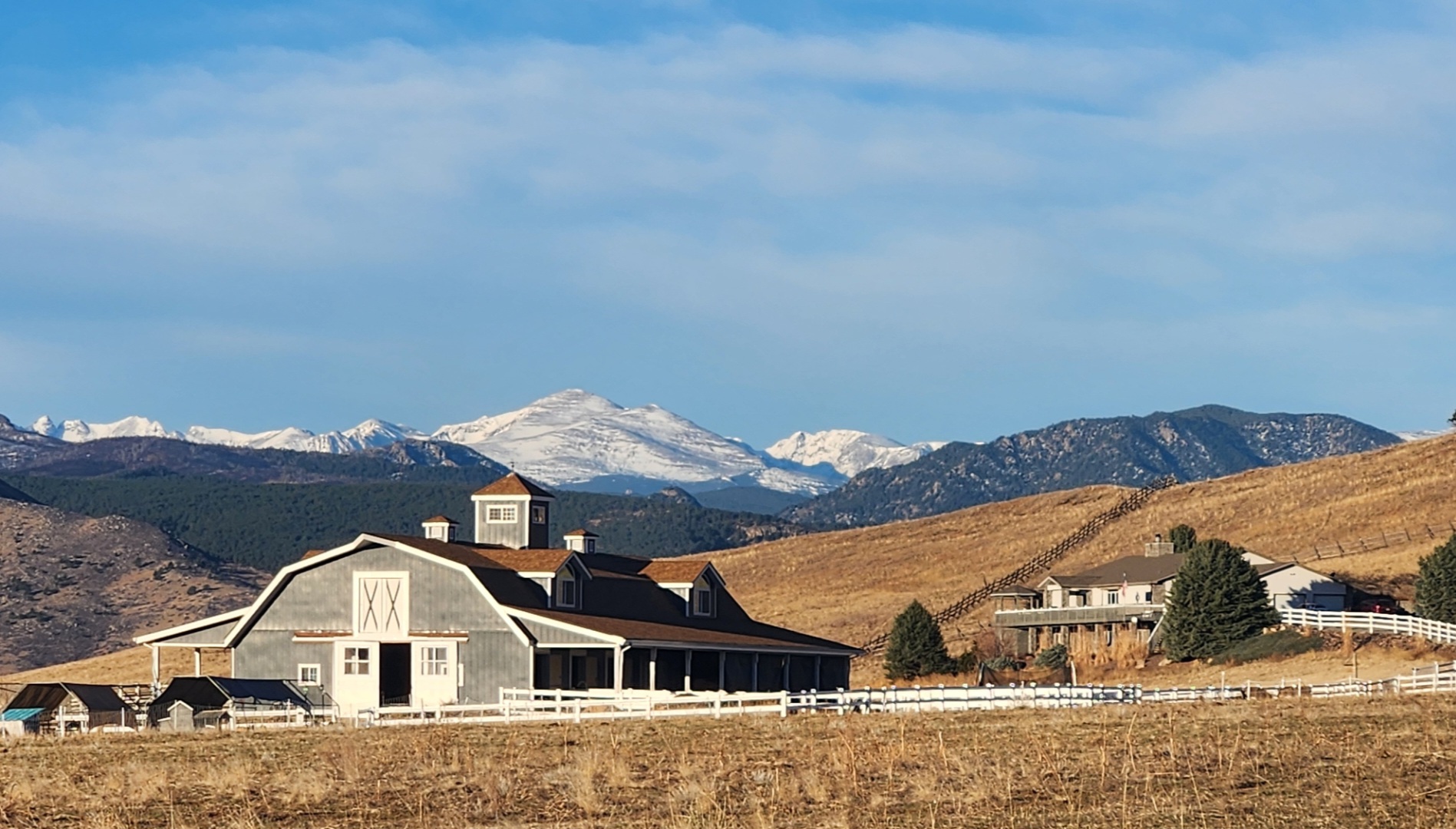 Lone Tree Acres main barn and property with dramatic snow-capped Rocky Mountains in the background